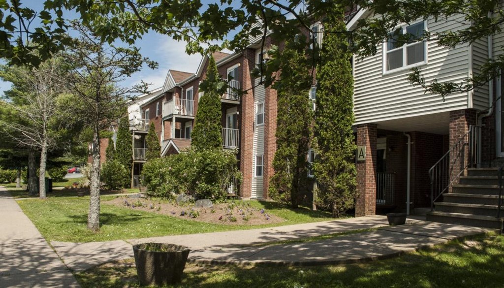 a row of houses with a sidewalk in front of them