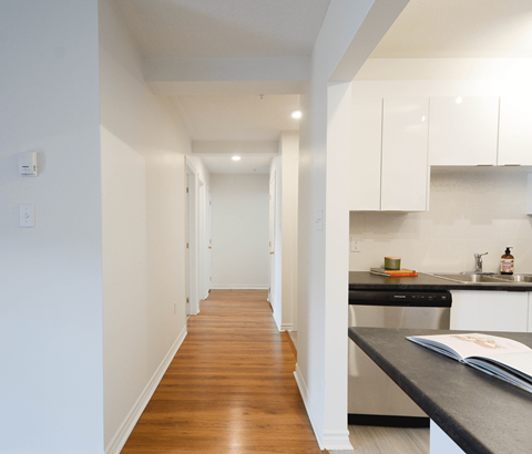 A kitchen with white cabinets and a black countertop.