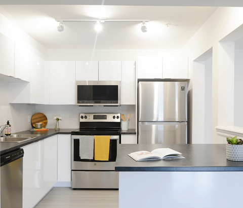 A modern kitchen with a stainless steel refrigerator and a black oven.