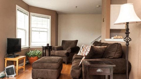 A living room with brown furniture and a flat screen TV.