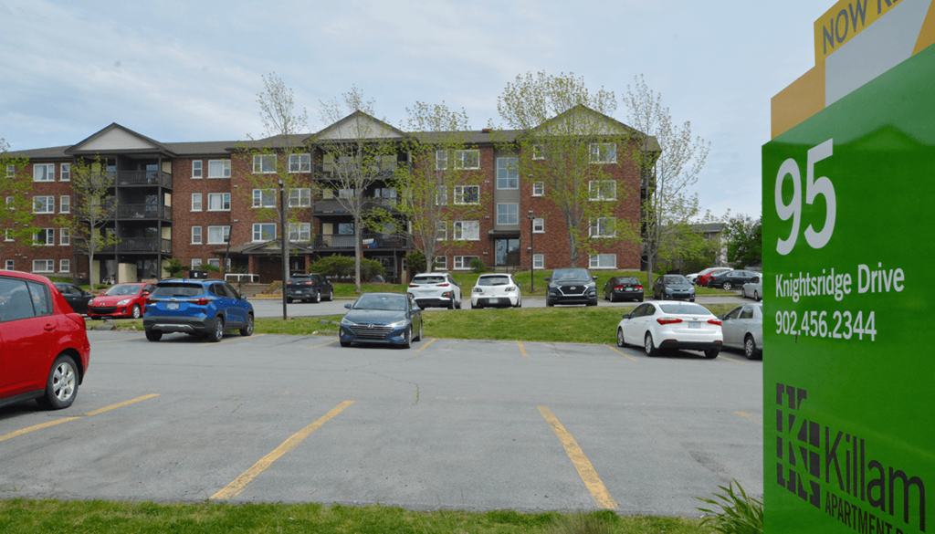 A parking lot with cars and a building in the background.