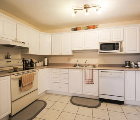 A kitchen with white cabinets and appliances.