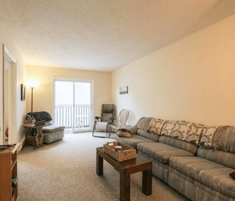 A living room with a couch, chair, and table.
