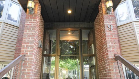 A building with a glass door flanked by two pillars with the number 9 on them.