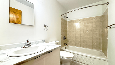 A bathroom with a white sink and a white toilet.