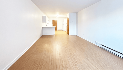 A long hallway with a kitchen area at the end.