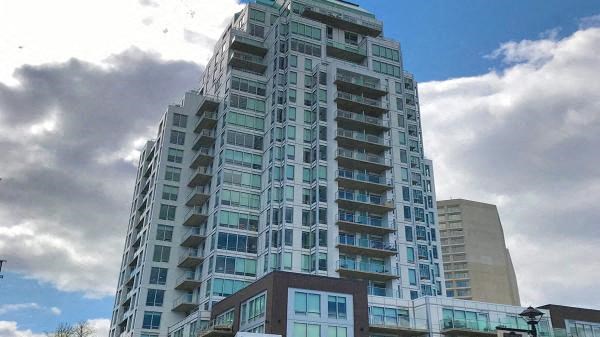 a tall building with many windows and a cloudy sky