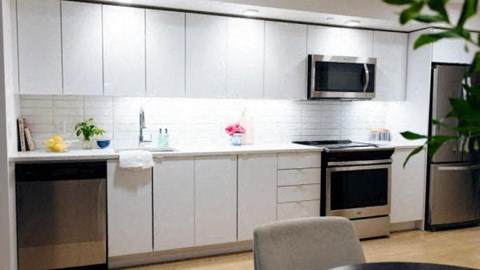 a white kitchen with a stove and a microwave