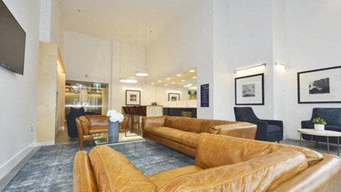 a living room with brown couches and a blue rug