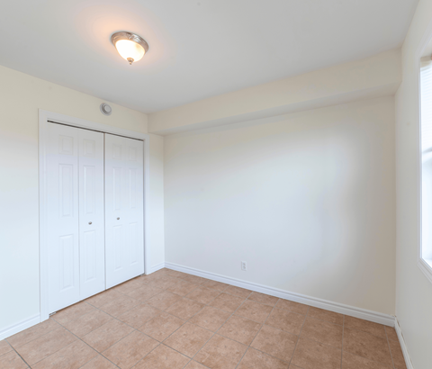 A room with a white door and a brown floor.