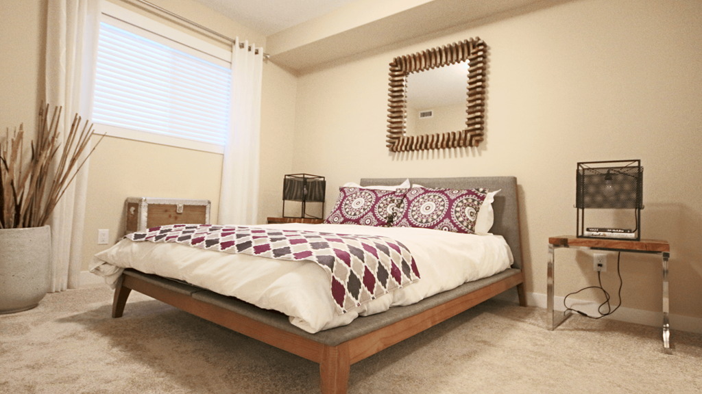 a bedroom with a bed and a mirror on the wall