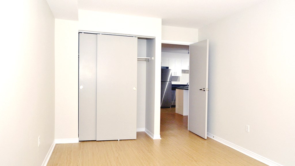 a bedroom with white walls and sliding closet doors