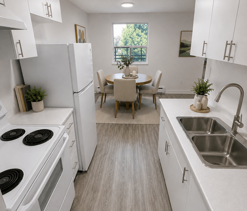 A kitchen with white appliances and a dining table with chairs.