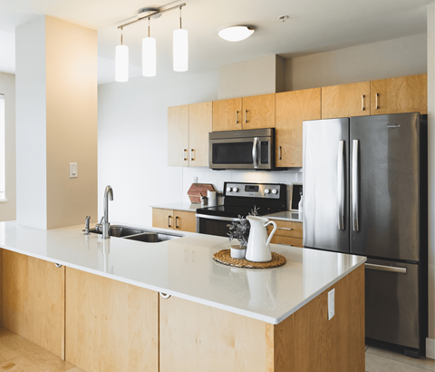 A modern kitchen with wooden cabinets and stainless steel appliances.