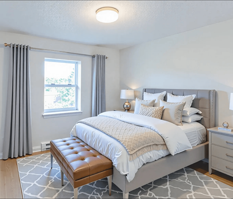 A bedroom with a large bed and a bench in front of it.
