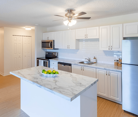 A kitchen with a marble countertop and stainless steel appliances.