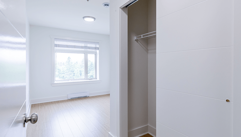 A white door is open to a room with a window.