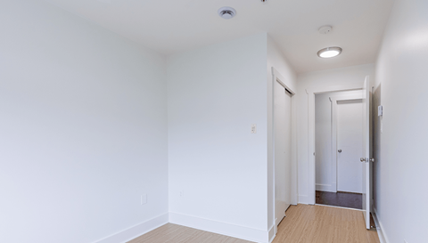 A white room with a doorway leading to another room.