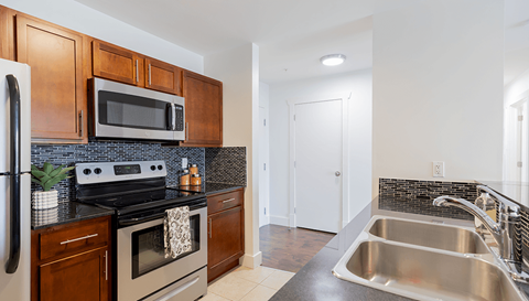 A kitchen with a stove, oven, microwave, and sink.
