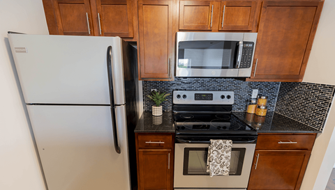 A white refrigerator is in a kitchen next to a stove.