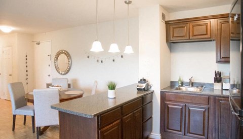 A kitchen with a dining table and chairs.
