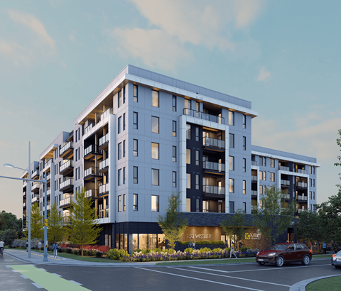 A modern apartment building with a parking lot in front.
