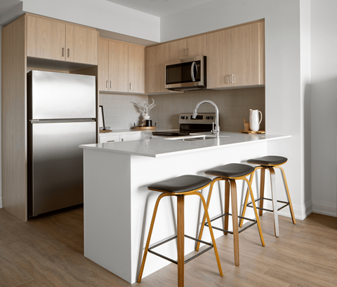 A kitchen with a white counter and wooden cabinets.