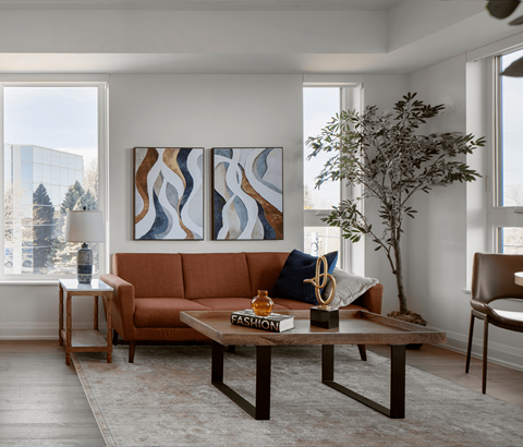 A living room with a brown couch, a coffee table, and a large painting on the wall.