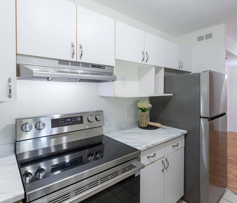A modern kitchen with a stainless steel oven and white cabinets.