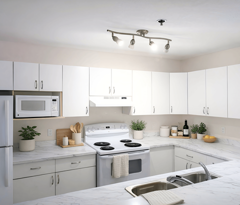 A kitchen with white cabinets and a white fridge.