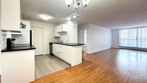 A kitchen with white cabinets and a black countertop.