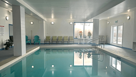 A large indoor swimming pool with a glass bottom.