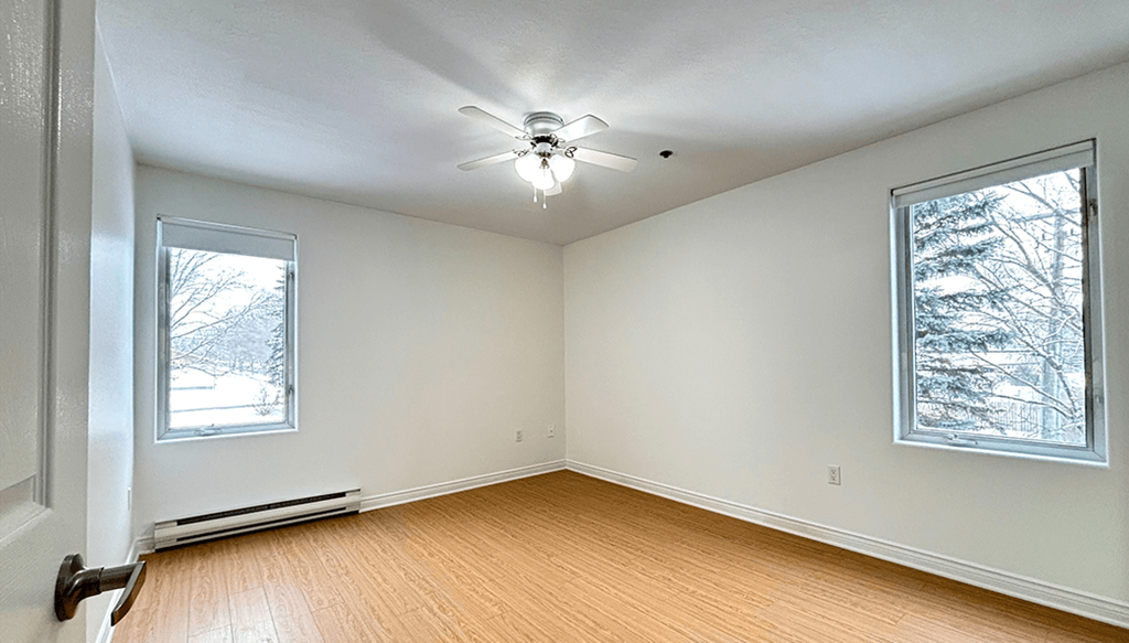 A room with a window and a ceiling fan.