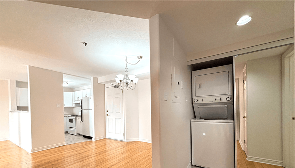A kitchen with a refrigerator, oven, and a chandelier.