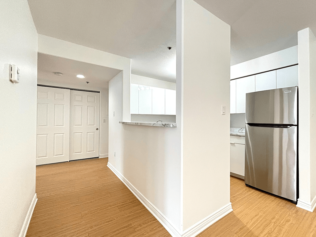 A kitchen with a refrigerator and a white door.