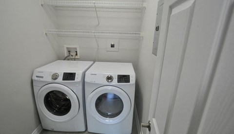 a white washer and dryer in a small laundry room