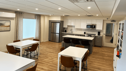 a kitchen and dining room with white tables and chairs