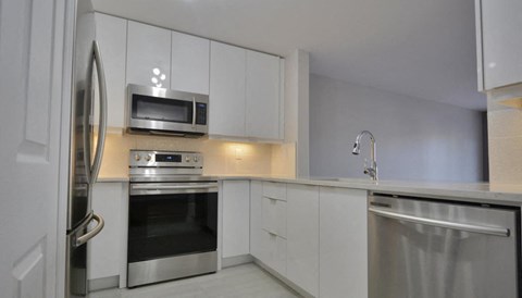 a kitchen with stainless steel appliances and white cabinets