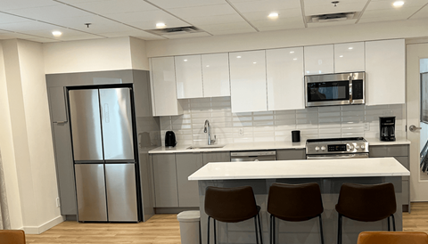 a kitchen with a white counter top and a stainless steel refrigerator
