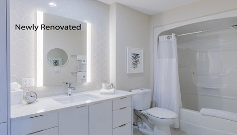 a white bathroom with a shower toilet and sink