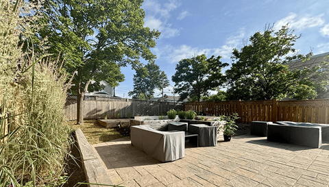 A backyard with a wooden deck and a hot tub.