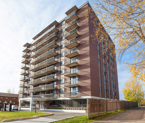 A tall apartment building with balconies on each floor.