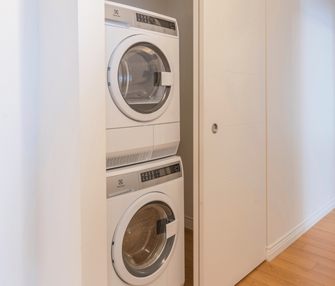 A white washing machine is placed in a small room.