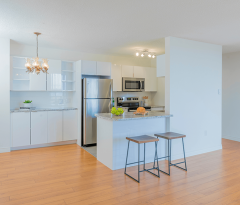 A kitchen with white cabinets and a wooden island.