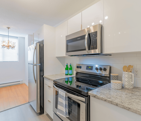 A modern kitchen with a stove, oven, and microwave.