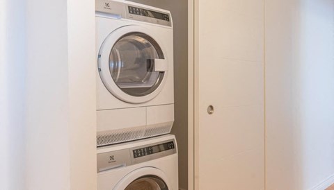 a white washer and dryer in a white closet