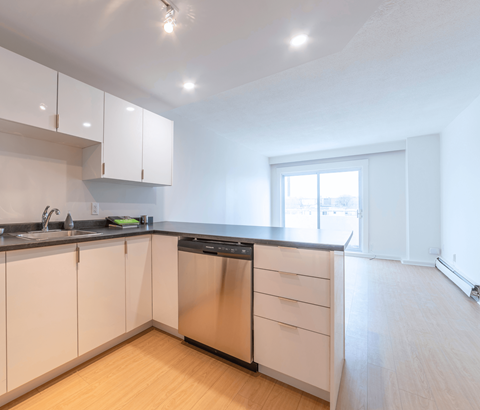 A kitchen with white cabinets and a black dishwasher.