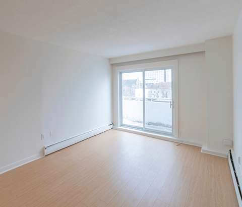 Empty room with a sliding glass door leading to a balcony.