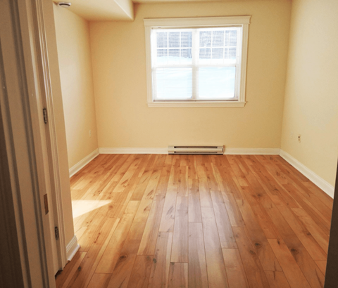 A room with wooden flooring and a window.