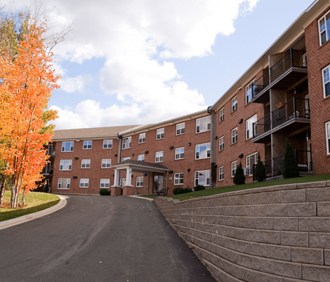 A large apartment complex with a driveway in front.